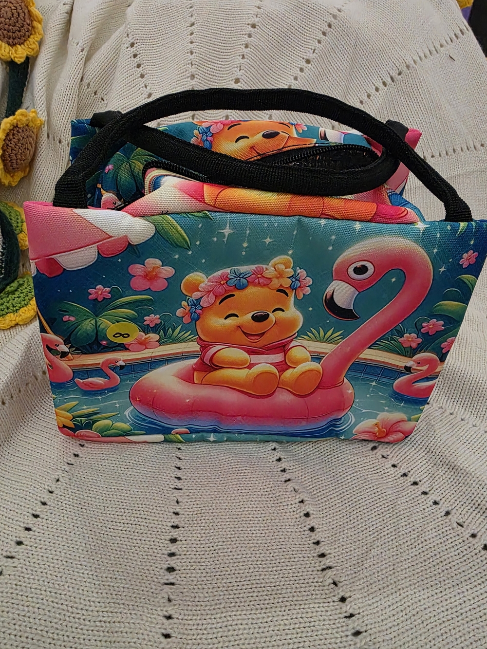 Insulated lunch bag features a playful design of Winnie the Pooh wearing a color